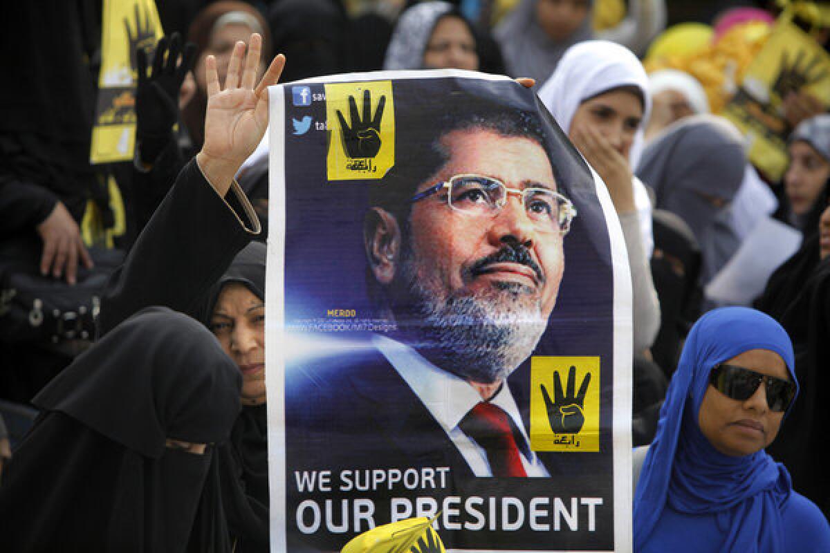 Supporters of Egypt's ousted president Mohamed Morsi carry a picture of him Friday during a protest in Cairo.