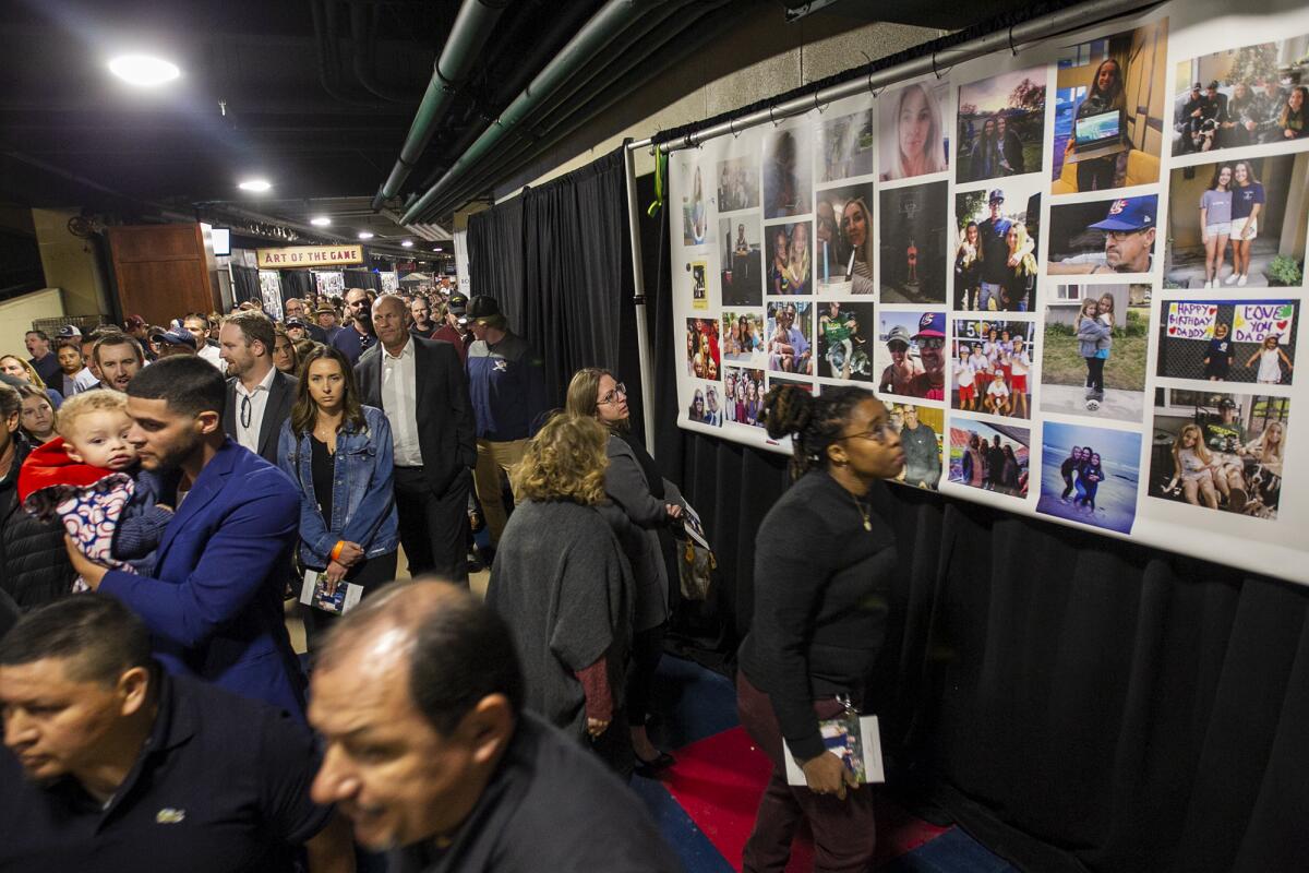 Guests look at Altobelli family photos during Monday's memorial at Angel Stadium.