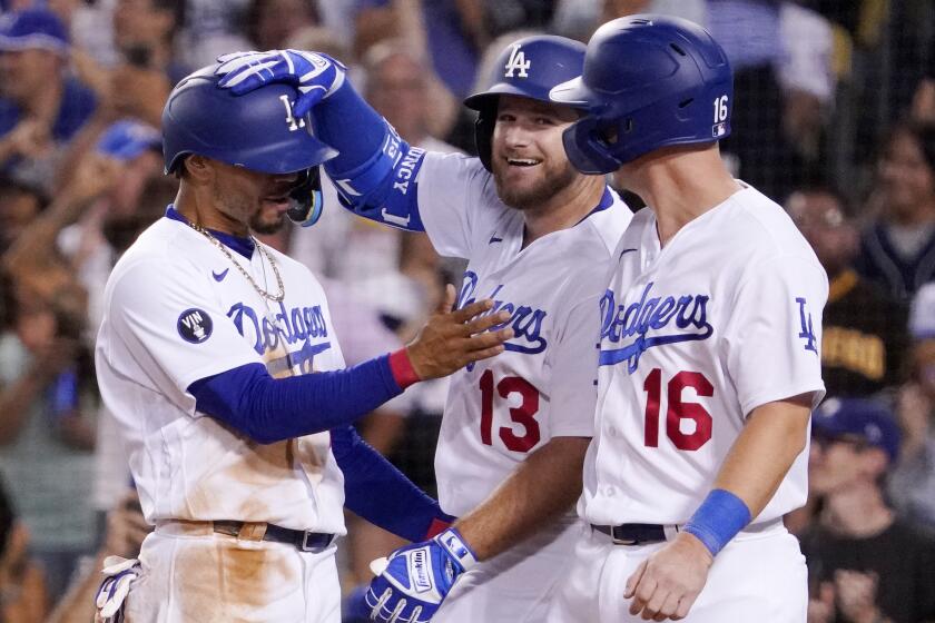 Los Angeles Dodgers' Max Muncy, center, is congratulated by Mookie Betts.