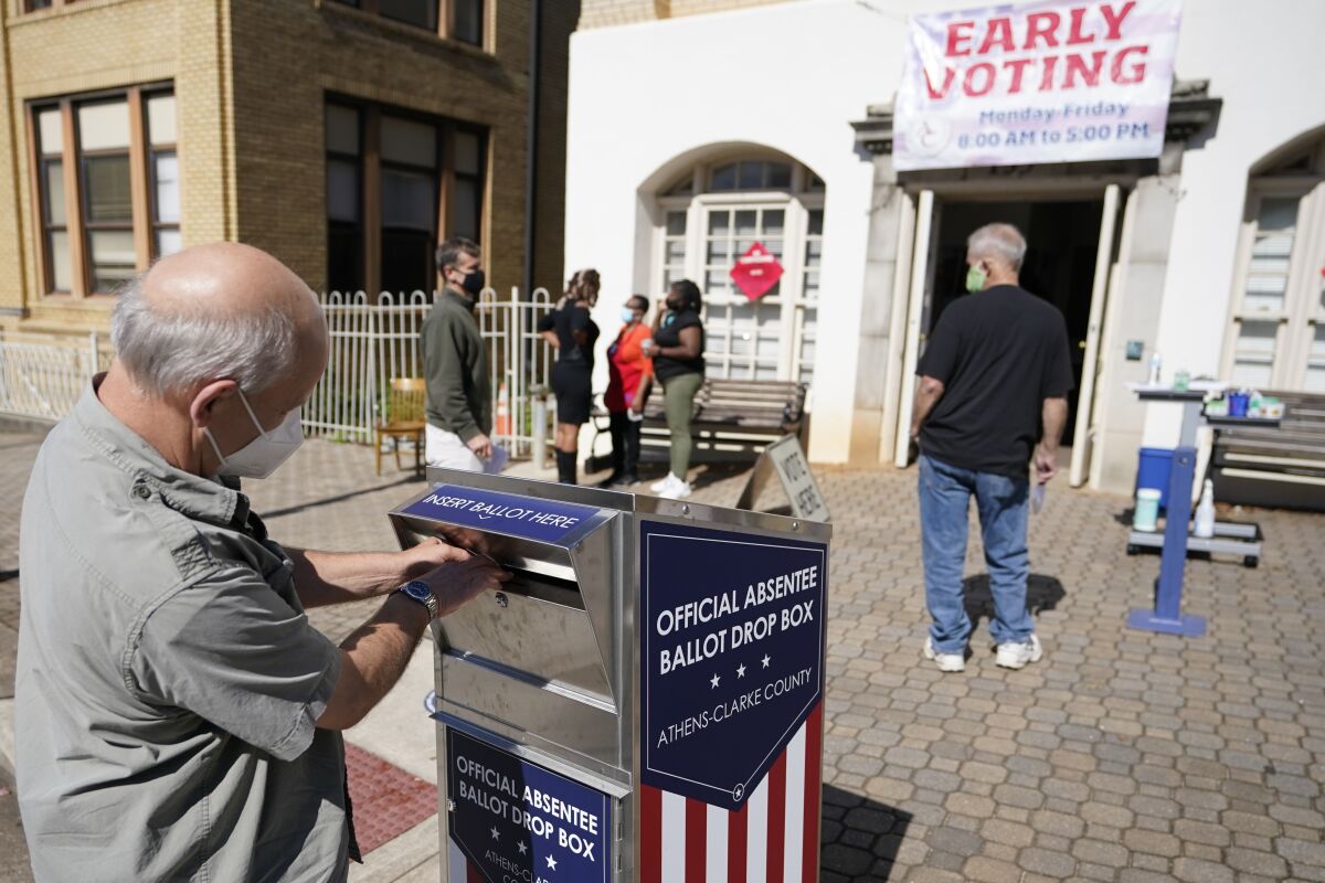 A man drops a ballot into a drop box outside a voting center in 2020.