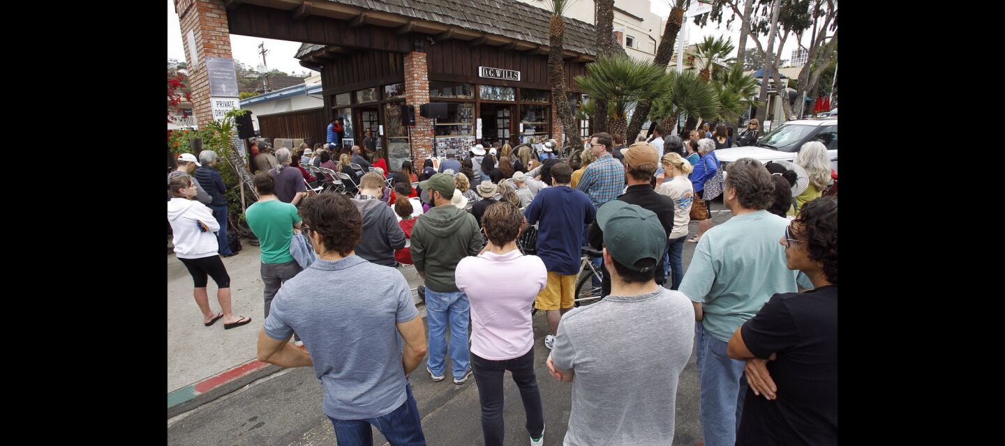 People gather outside at D.G. Wills Books in La Jolla on Saturday as they listen to actor Sean Penn, who is inside, talk about his book 'Bob Honey Who Just Do Stuff' over a speaker system.