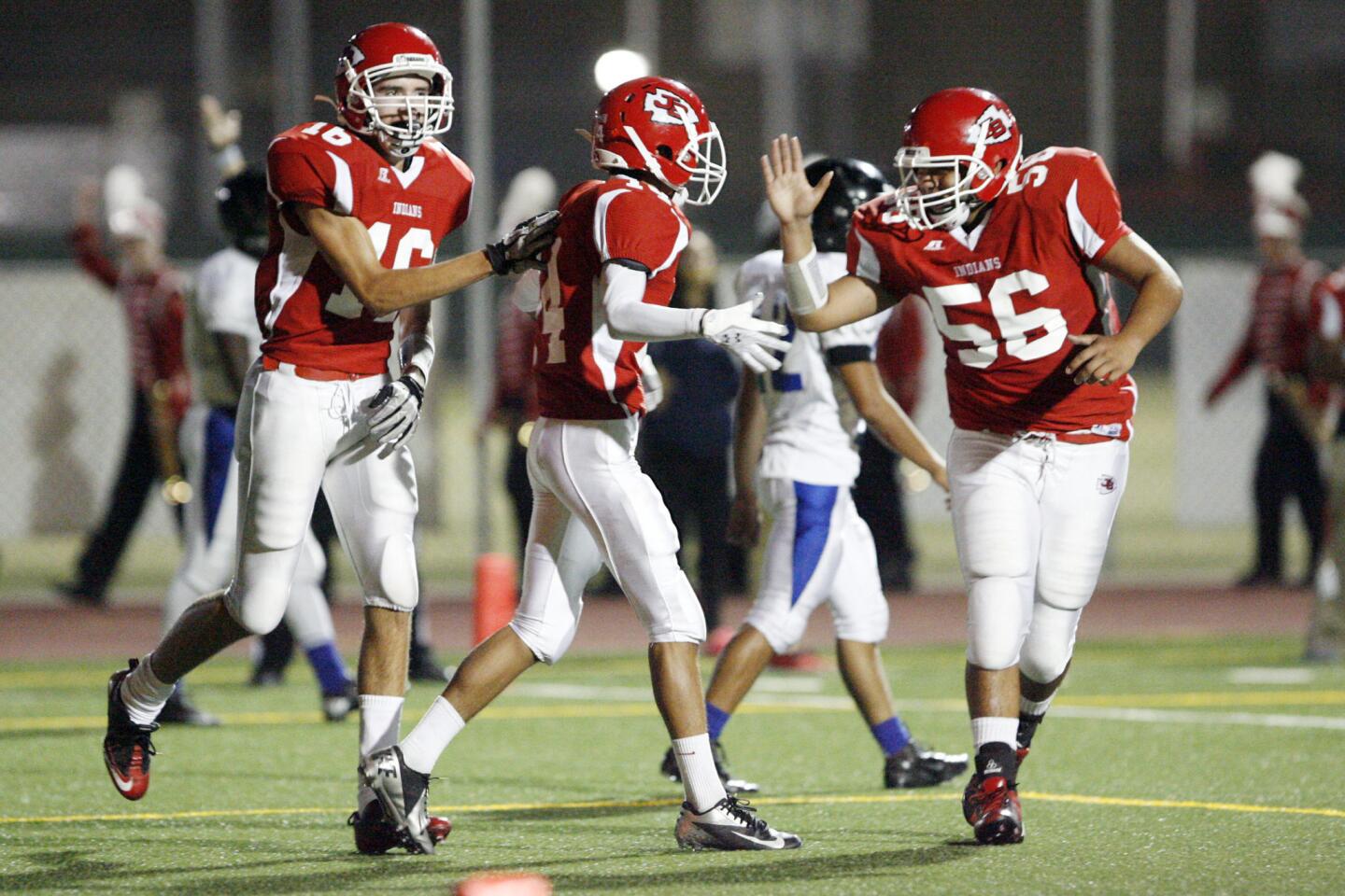 Burroughs' Conor Joyce, from left, Jonathan Fuentes and Victor Mora give each other high fives after Fuentes makes a touchdown during a game against North Hollywood at John Burroughs High School in Burbank on Friday, September 7, 2012.