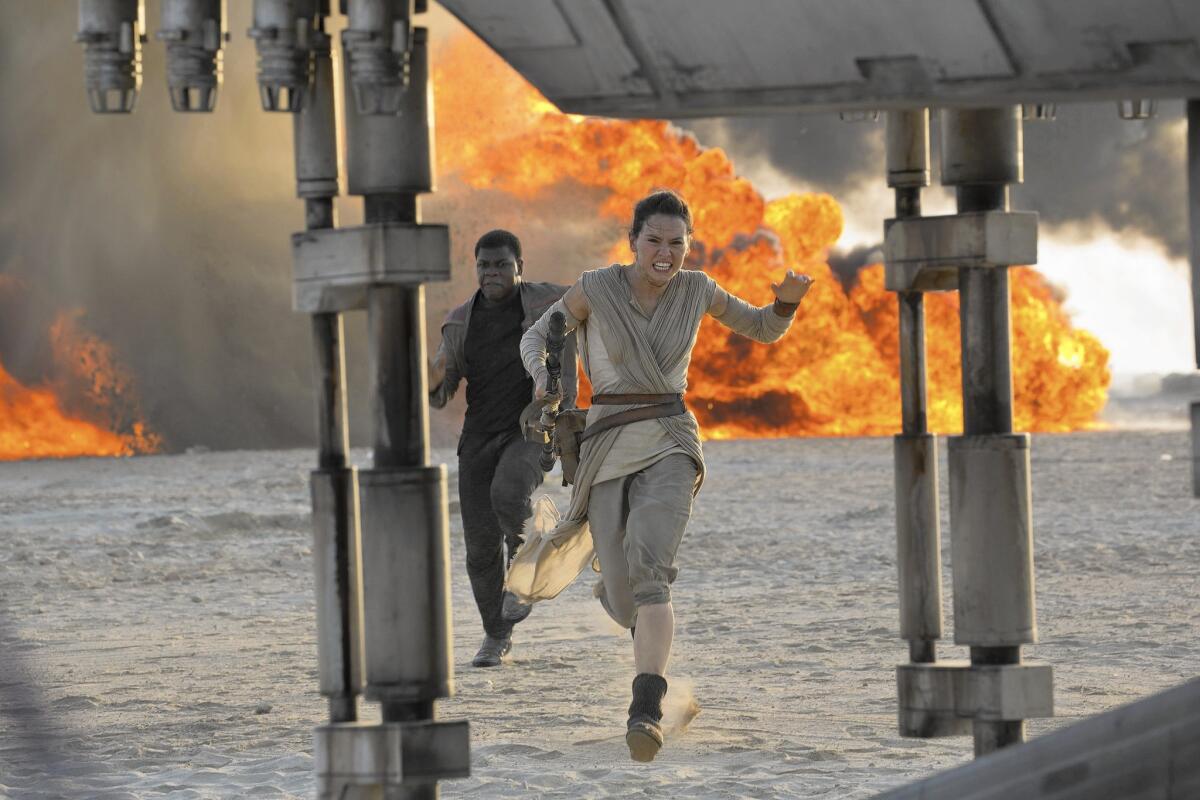 Daisy Ridley, right, as Rey, and John Boyega as Finn, in a scene from the film, "Star Wars: The Force Awakens."