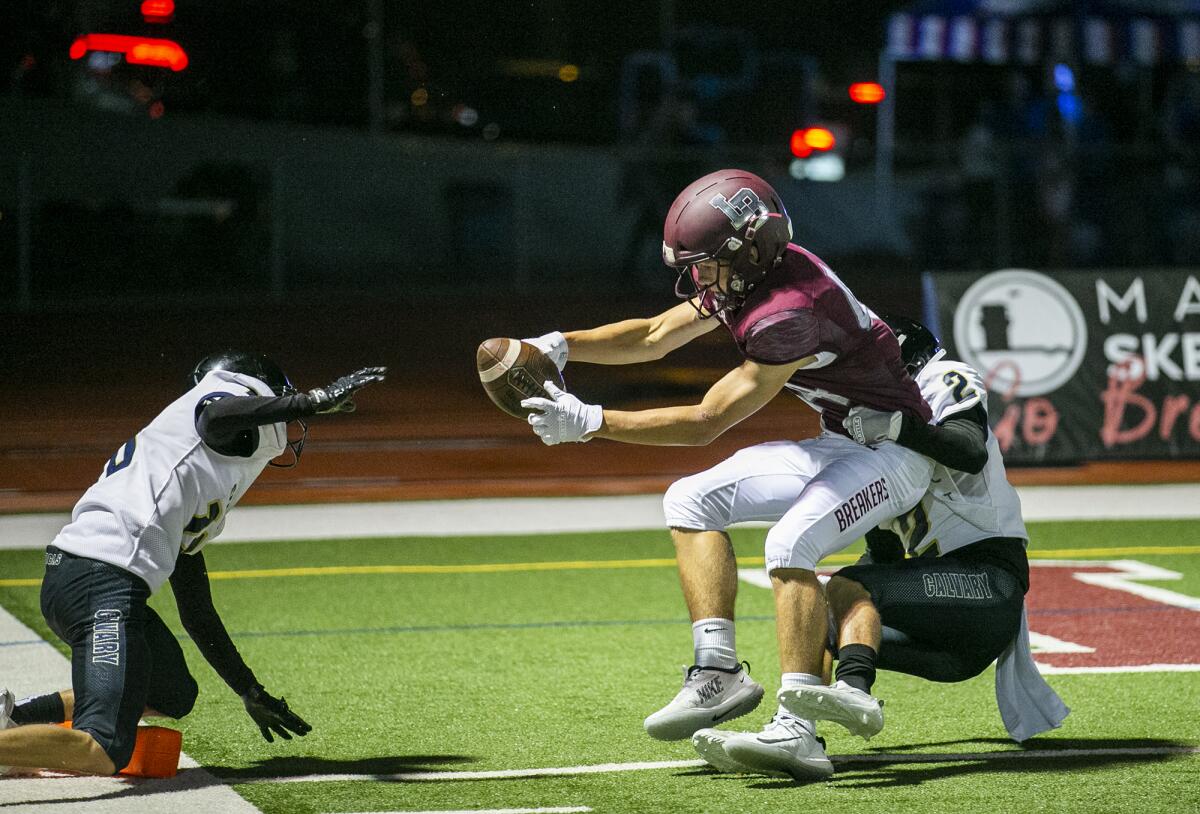 Laguna Beach's Jacob Diver stretches for the end zone while being tackled by Calvary Chapel's Jackson Pellkofer.