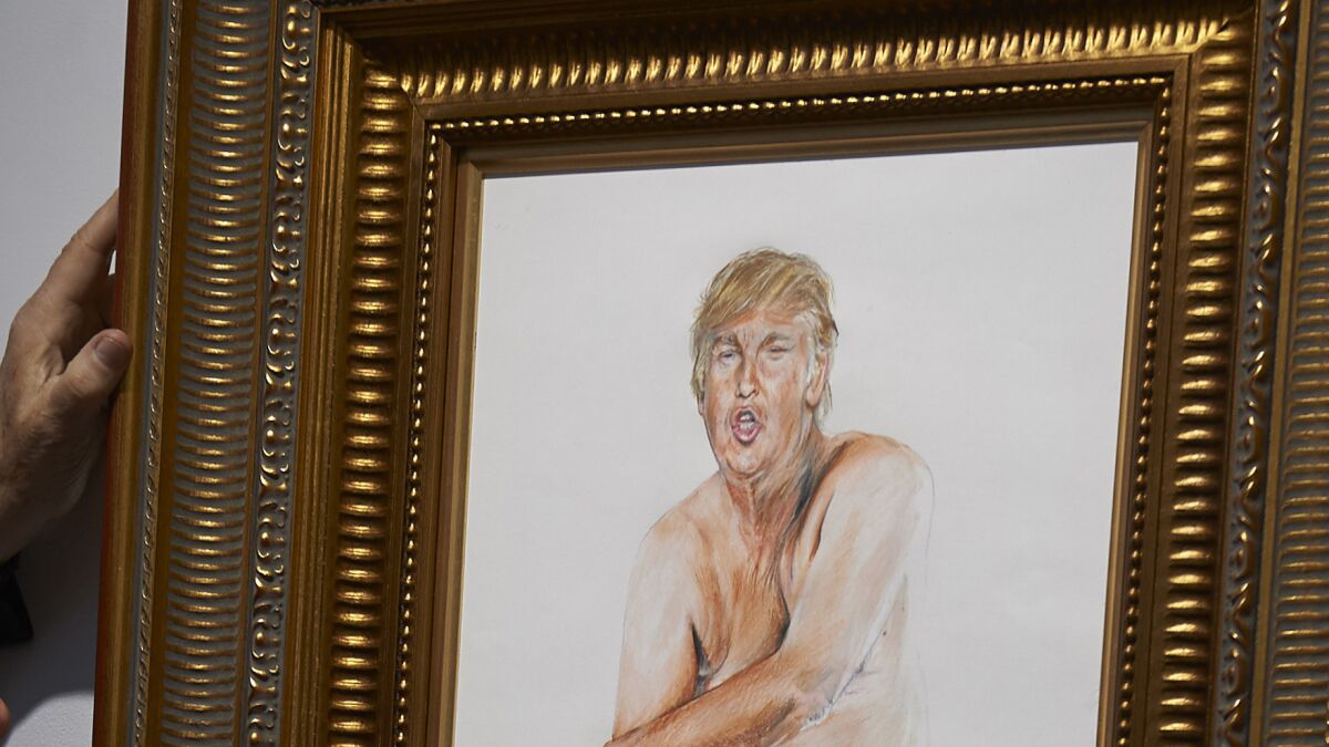 A curator adjusts a painting of Donald Trump by Illma Gore at an exhibition in London. (Niklas Halle'n / AFP/Getty Images)