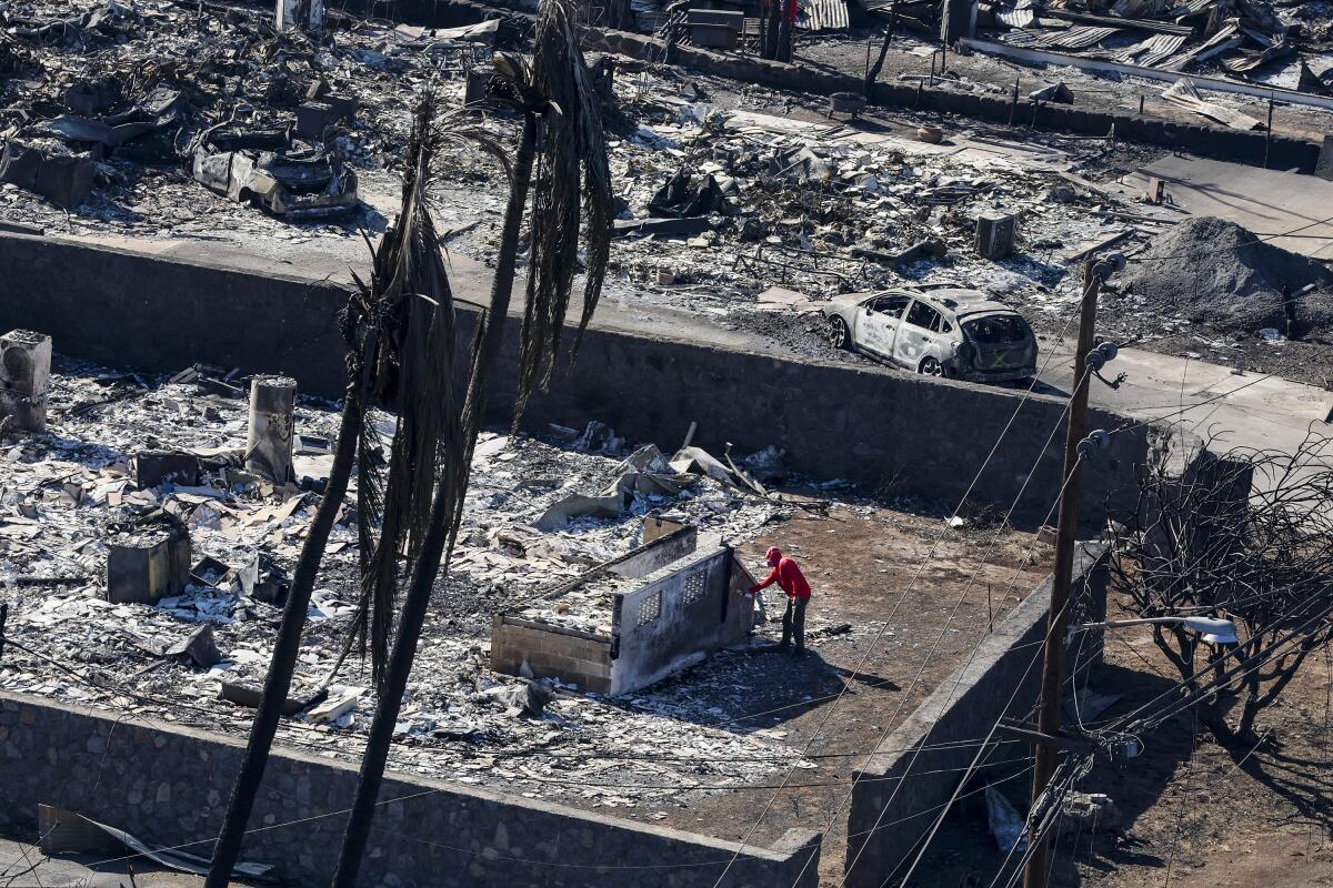 An official marks a structure after looking over a burned out property in Lahaina.