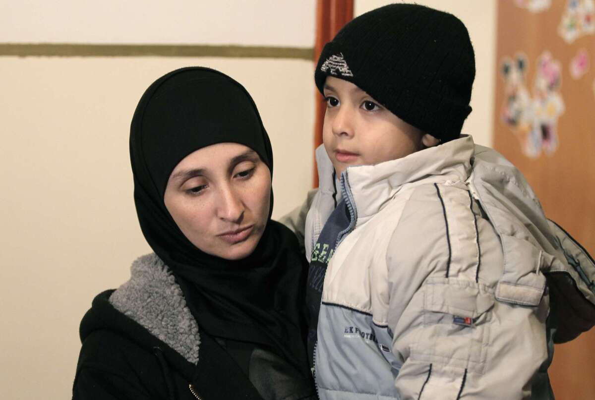 Nadia Abu Jamal, widow of Ghassan Abu Jamal, who carried out a deadly attack on a Jerusalem synagogue, holds her son Nov. 26 in their house in East Jerusalem.