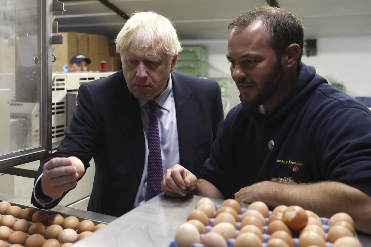 British Prime Minister Boris Johnson, left, with Matt Shervington-Jones at his farm in Wales on July 30, 2019.