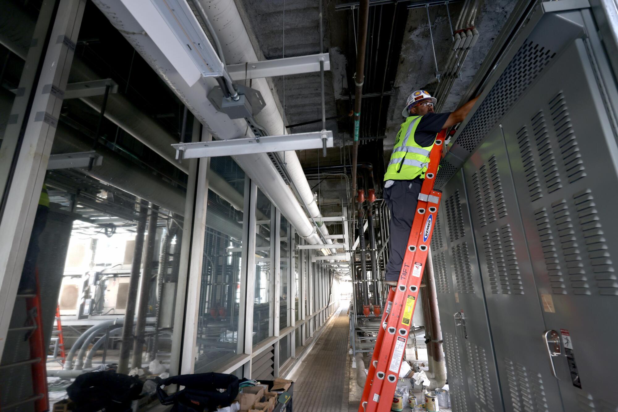 Electrician Oscar Rivas works on a new generator system on the third floor of One Wilshire.