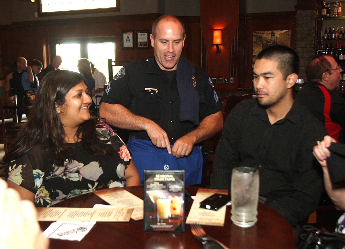 Burbank Sgt. Jeff Lamoureaux talks with a table of guests, including Kajal Pridedi of Beverly Hills, and Alek Beluna of Woodland Hills, about a fundraiser he is helping with at Claim Jumper in Burbank on Thursday, April 17, 2014. Officers from the Burbank Police Department helped with tables as a fundraiser for the Special Olympics.