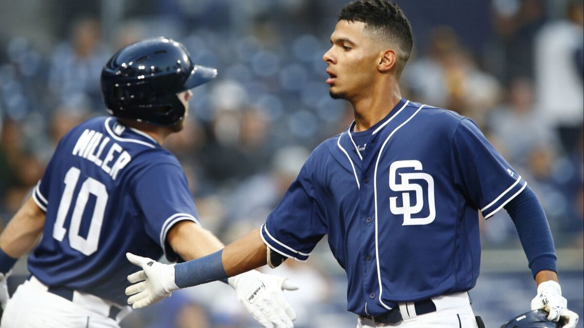 Padres third baseman Tucupita Marcano (right) low-fives Owen Miller after hitting an RBI double in the first inning on Sept. 27, 2018, at Petco Park.