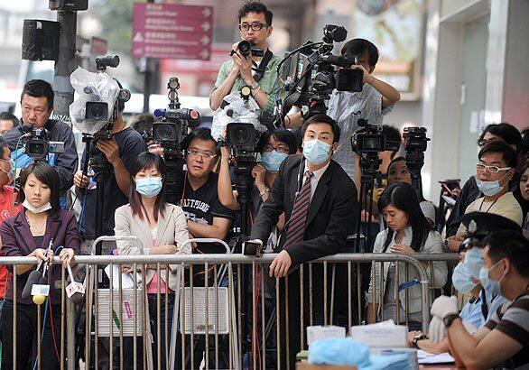 Media crews wait for developments outside Hong Kong's Metropark Hotel. Complete Coverage: Swine flu