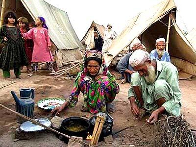 Bibi Aqbiqa, left, and her husband, Aga Mohammed, prepare dinner in the newer section of the Jalozai refugee camp for Afghans near Peshawar, Pakistan.