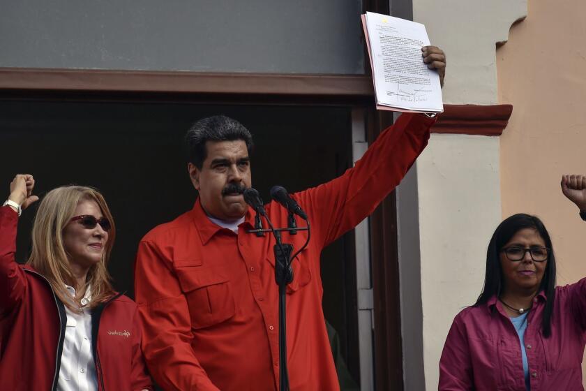 Venezuela's President Nicolas Maduro (C), speaks to a crowd of supporters flanked by his wife Cilia Flores (L) and Venezuela's Vice-president Delcy Rodriguez, during a gathering in Caracas on January 23, 2019. - National Assembly head Juan Guaido proclaimed himself Venezuela's "acting president" on Wednesday in a bid to oust leftist President Nicolas Maduro. (Photo by Luis ROBAYO / AFP)LUIS ROBAYO/AFP/Getty Images ** OUTS - ELSENT, FPG, CM - OUTS * NM, PH, VA if sourced by CT, LA or MoD **