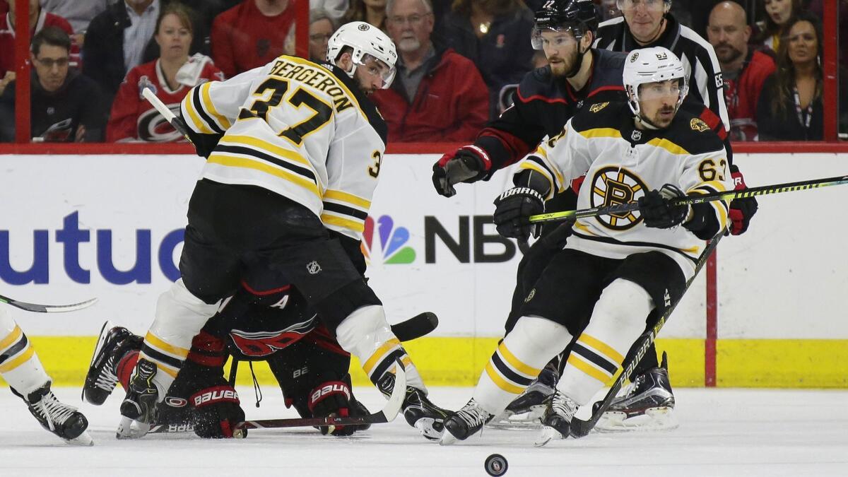 Boston Bruins' Patrice Bergeron (37) and Brad Marchand (63) skate for the puck with Carolina Hurricanes' Brett Pesce (22) and Jordan Staal during the second period in Game 3 of the NHL Eastern Conference final series in Raleigh, N.C. on Tuesday.