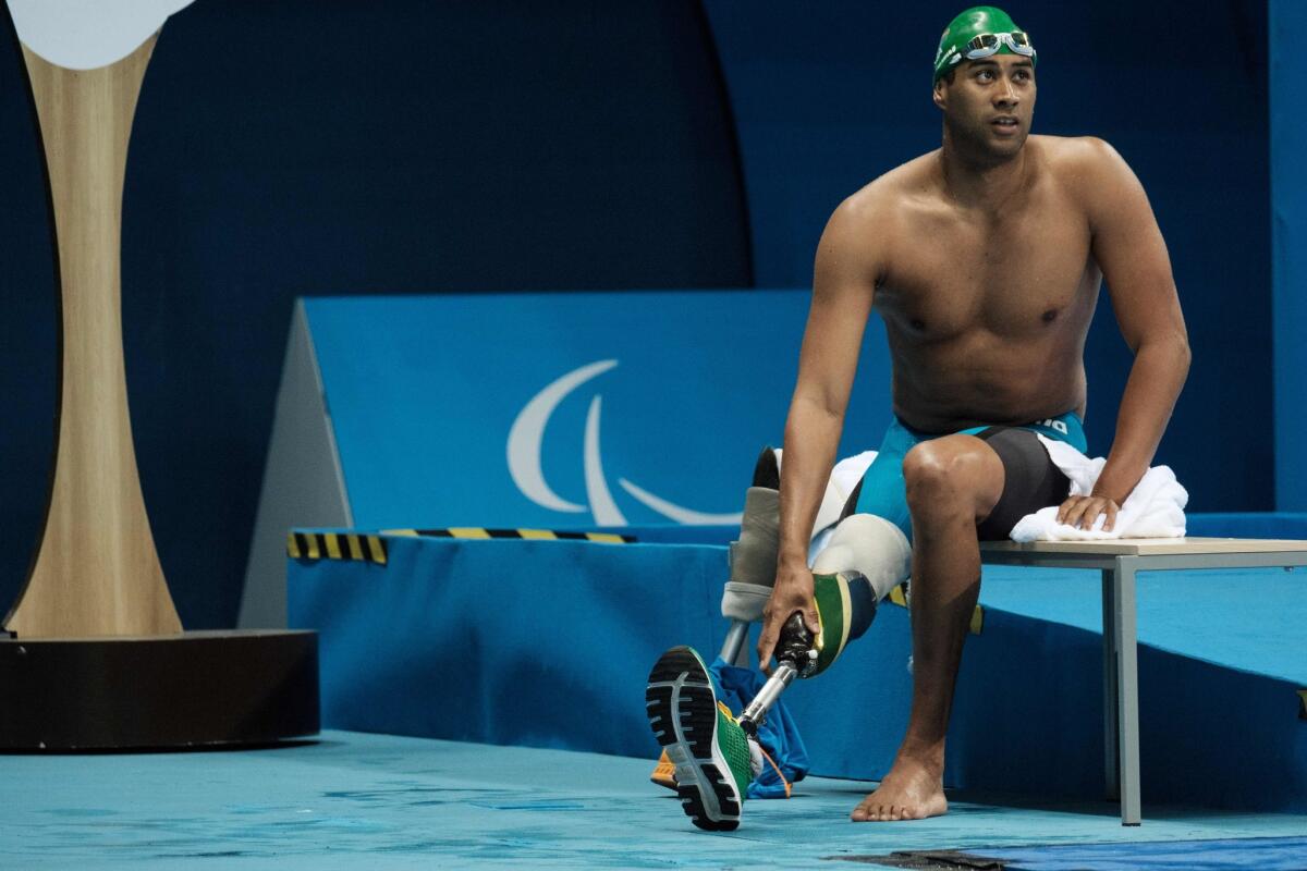 South Africa's Achmat Hassiem puts on his prosthesis after competing in a heat of the men's 100-meter freestyle at the 2016 Paralympic Games in Rio de Janeiro.