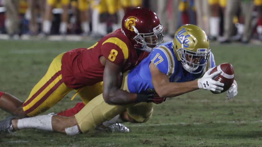 UCLA receiver Christian Pabico stretches out after making a catch in front of USC defensive back Iman Marshall.