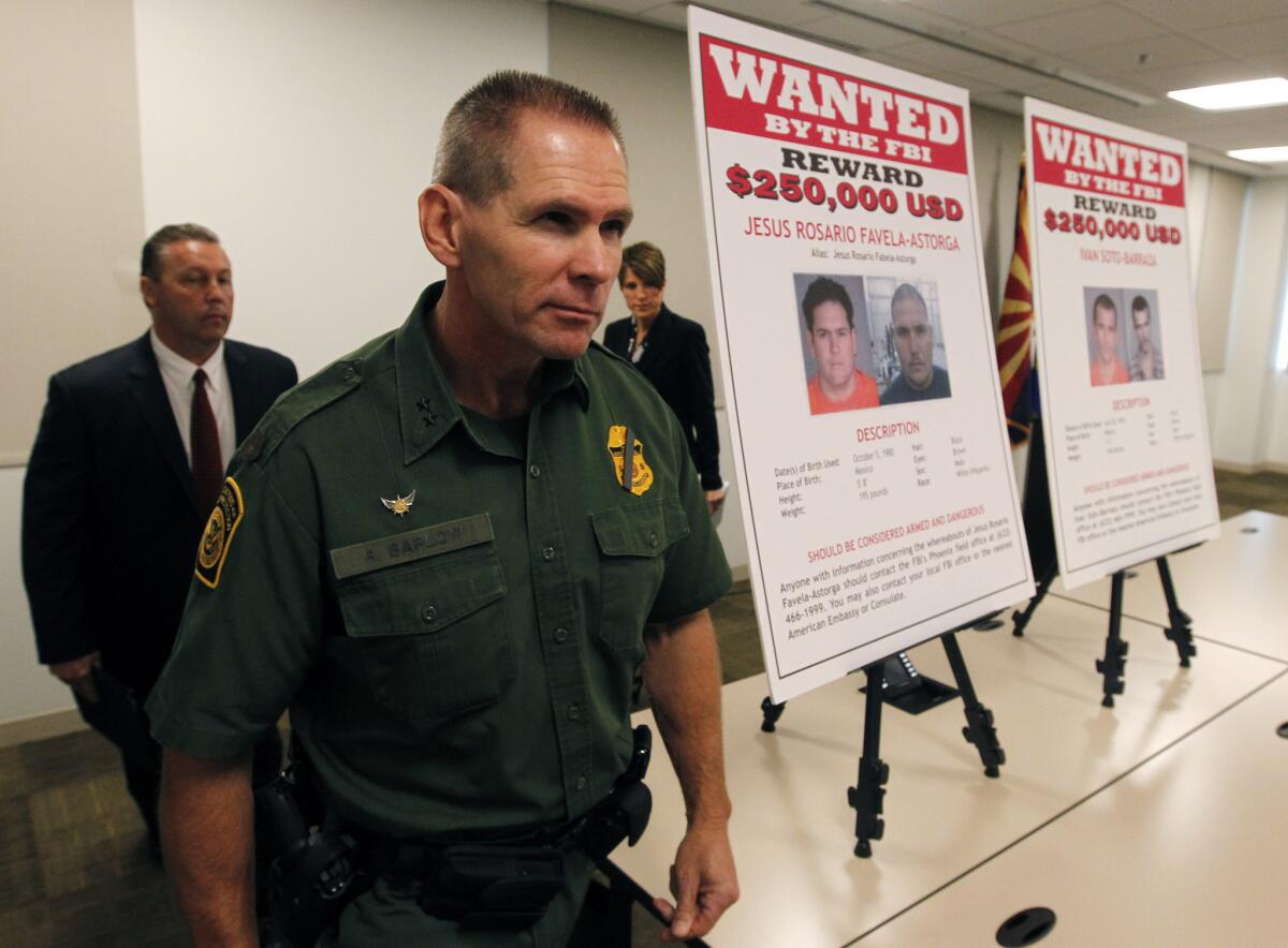 Richard Barlow, chief of the Tucson sector of the U.S. Border Patrol, foreground, and FBI Agent James L. Turgal Jr. leave a news briefing after announcing the indictment of five suspects related to the Fast & Furious operation.