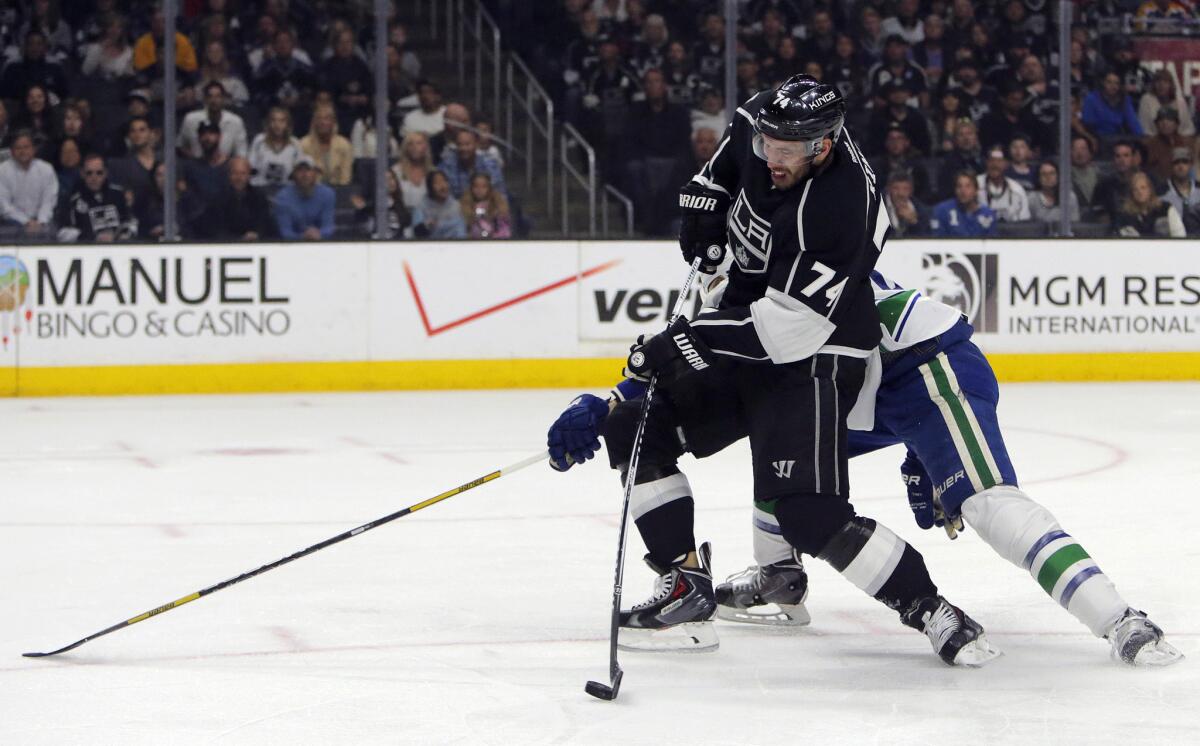 Kings left wing Dwight King (74) controls the puck on a breakaway with Canucks defenseman Chris Tanev (8) attempting to stop him during a game on March 21.
