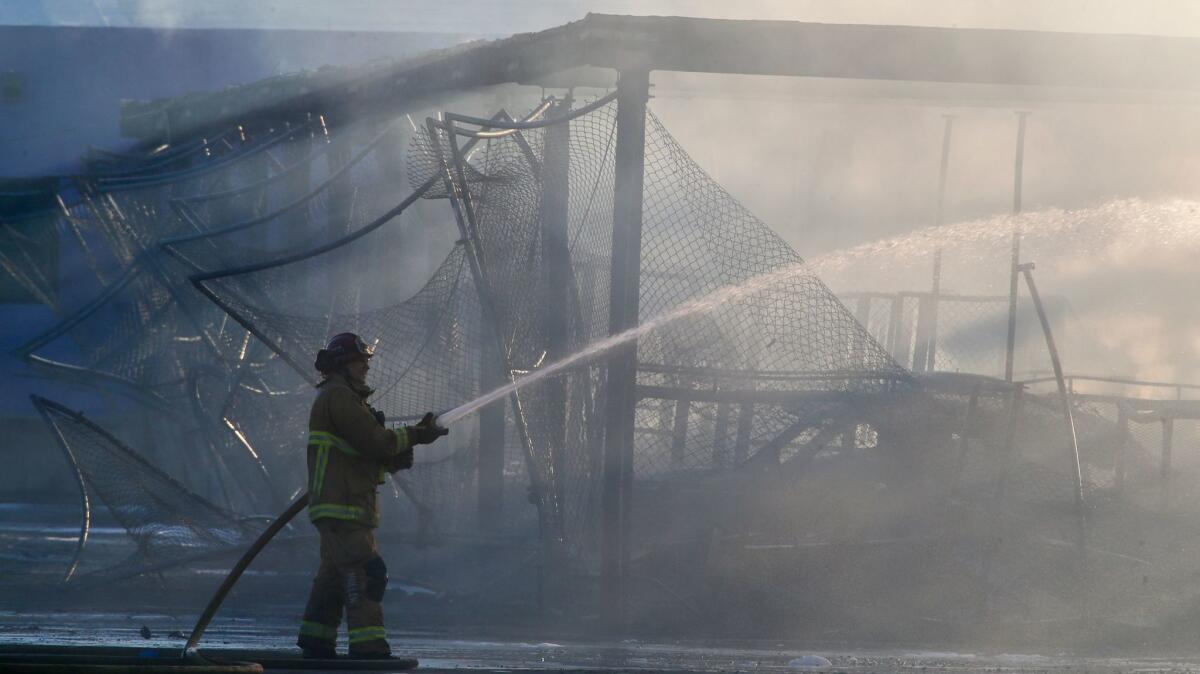 Firefighters from several agencies continue to battle a a stubborn fire in a storage facility at 864 Production Place in Newport Beach