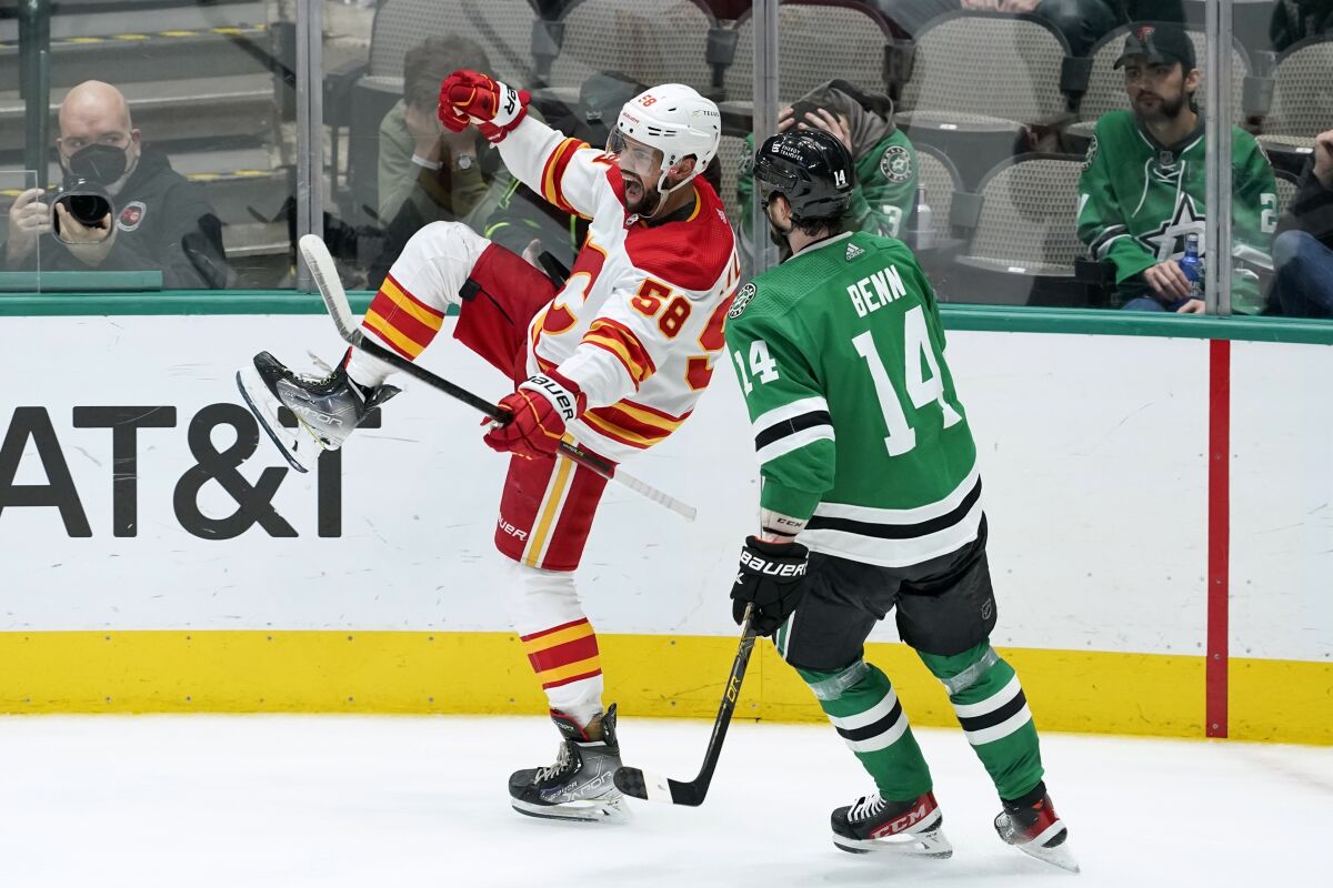 Calgary Flames defenseman Oliver Kylington (58) celebrates after scoring in front of Dallas Stars left wing Jamie Benn (14) in the third period of an NHL hockey game in Dallas, Tuesday, Feb. 1, 2022. (AP Photo/Tony Gutierrez)