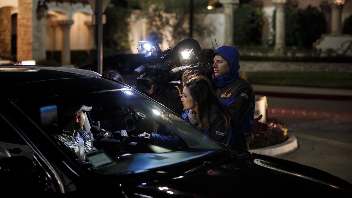 Reporters interview residents leaving a Porter Ranch gated community where a triple homicide was reported Monday.