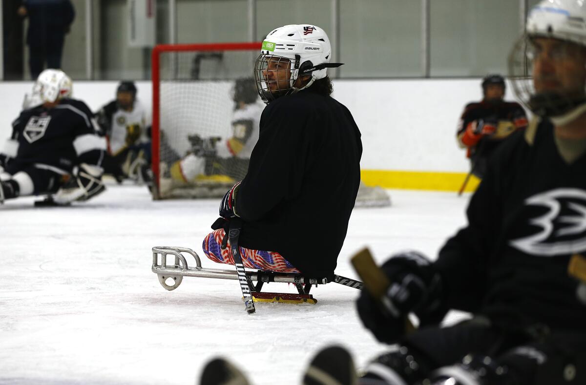 Ralph DeQuebec, a Paralympic hockey gold medalist from Harbor City, coaches players during a sled hockey clinic at Great Park Ice rinks in Irvine on Saturday.