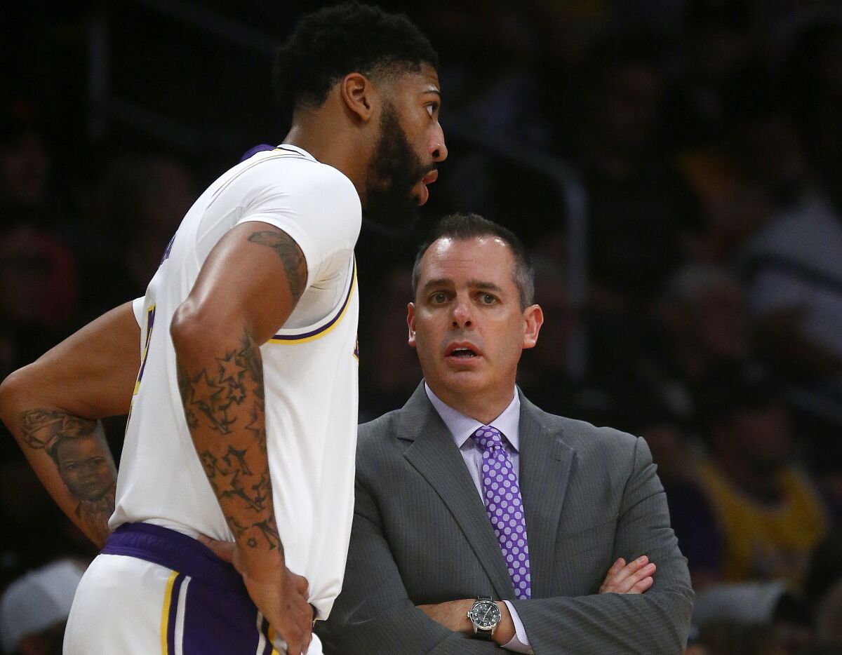 Lakers forward Anthony Davis chats with coach Frank Vogel during a game this season.