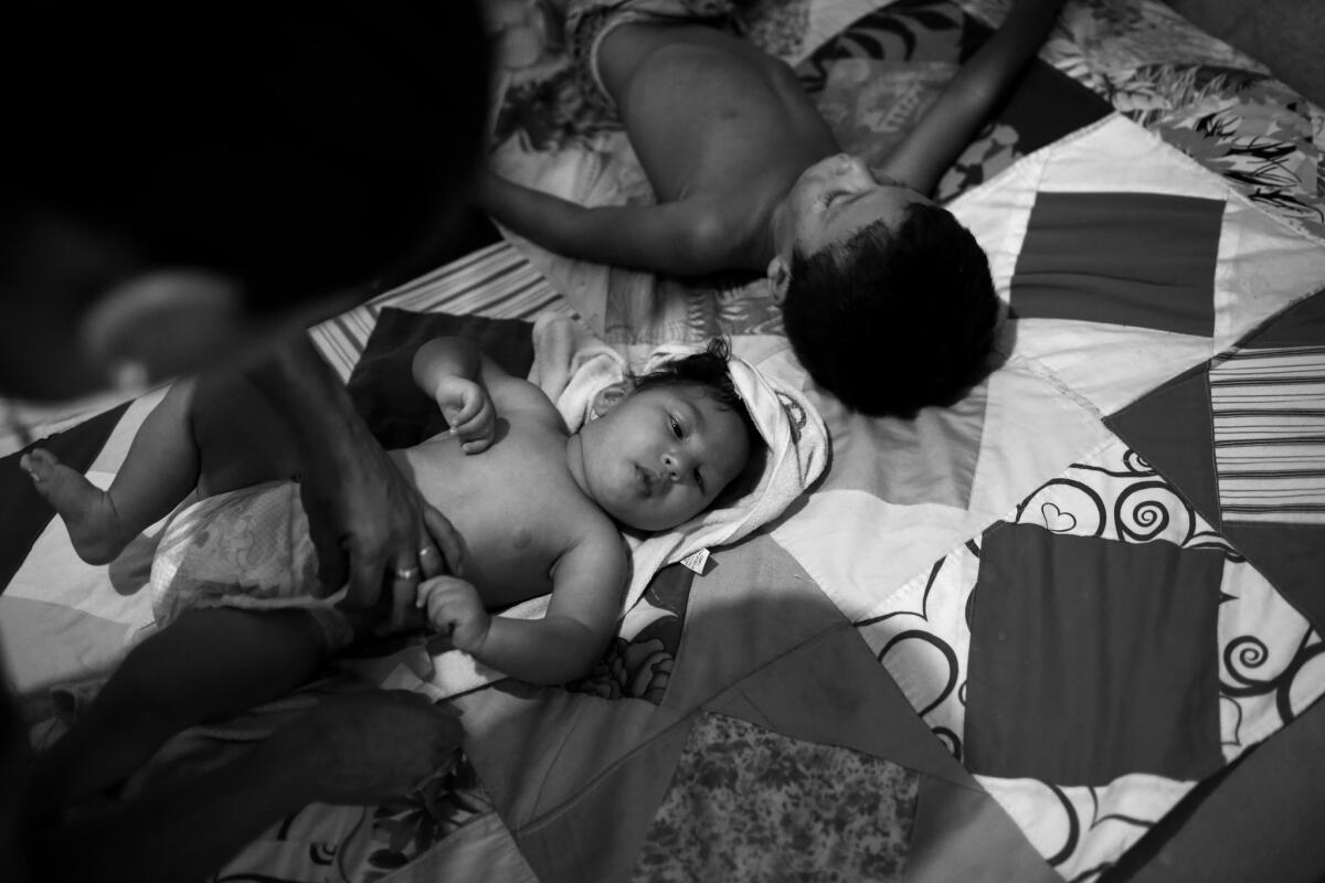 Gilberto has his diaper changed while Jorge takes a nap. The house is so small the boys share a bed with their mother.