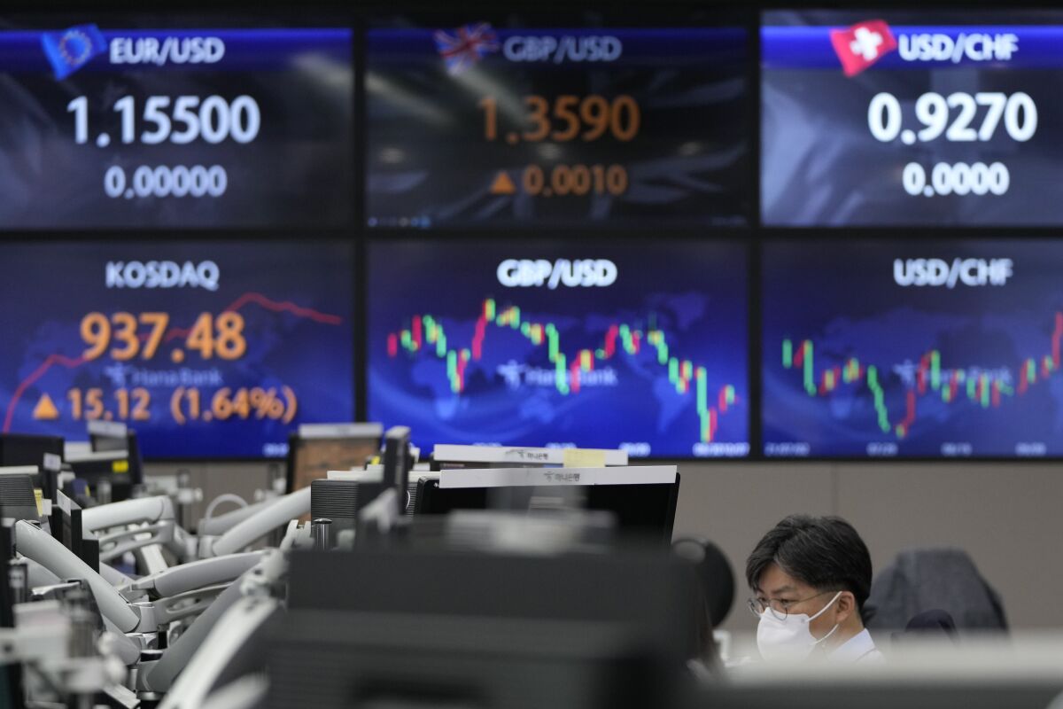 A currency trader watches computer monitors near the screens showing the Korean Securities Dealers Automated Quotations (KOSDAQ), left bottom, and the foreign exchange rates at a foreign exchange dealing room in Seoul, South Korea, Thursday, Oct. 7, 2021. Asian shares rose Thursday, tracking a rally on Wall Street. (AP Photo/Lee Jin-man)