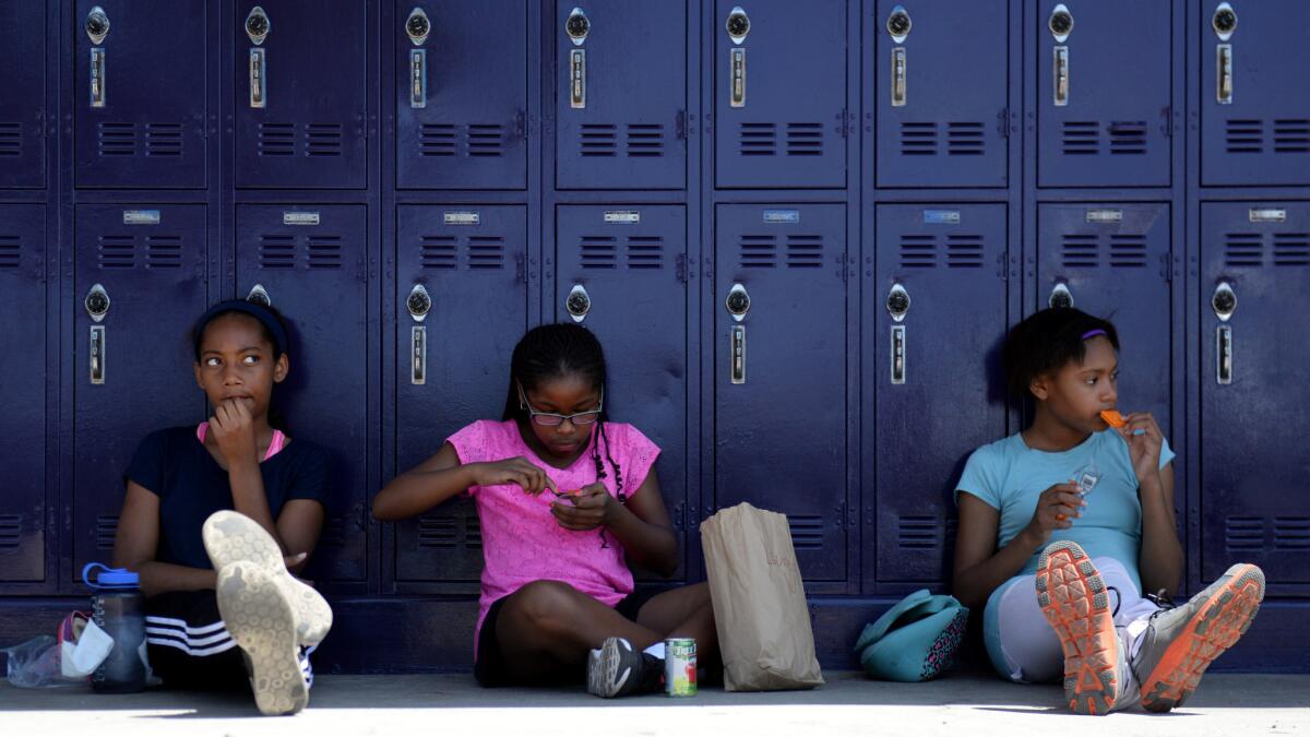 Marley Streeck, 11, from left, Lauren D. Wright, 10, and Grace Ajegbo, 11, sit together during their lunch break at the Girls Academic Leadership Academy (GALA) orientation in Los Angeles.
