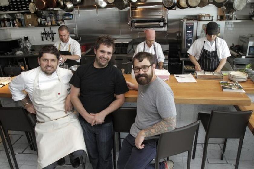 From left, Ludo Lefebvre (chef-co-owner), Vinny Dotolo (co-owner) and Jon Shook (co-owner) of the new Trois Mec restaurant with the kitchen staff behind them in the restaurant.