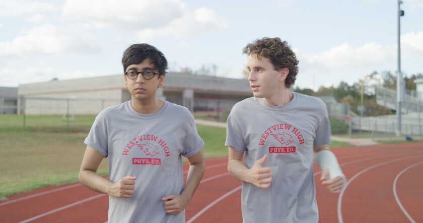 Two high school students jog on a track in the movie "Dear Evan Hansen."