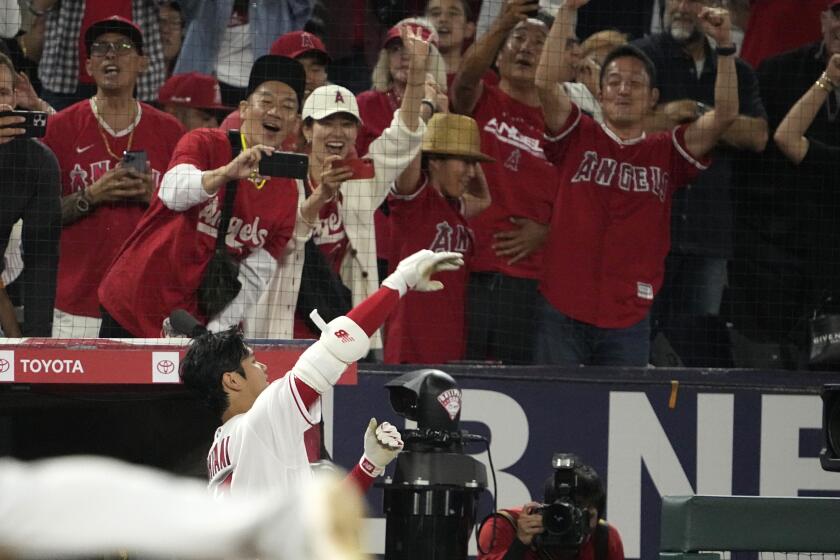 Los Angeles Angels' Shohei Ohtani celebrates from the dugout after hitting a solo home run during the seventh inning of a baseball game against the Chicago White Sox Tuesday, June 27, 2023, in Anaheim, Calif. (AP Photo/Mark J. Terrill)