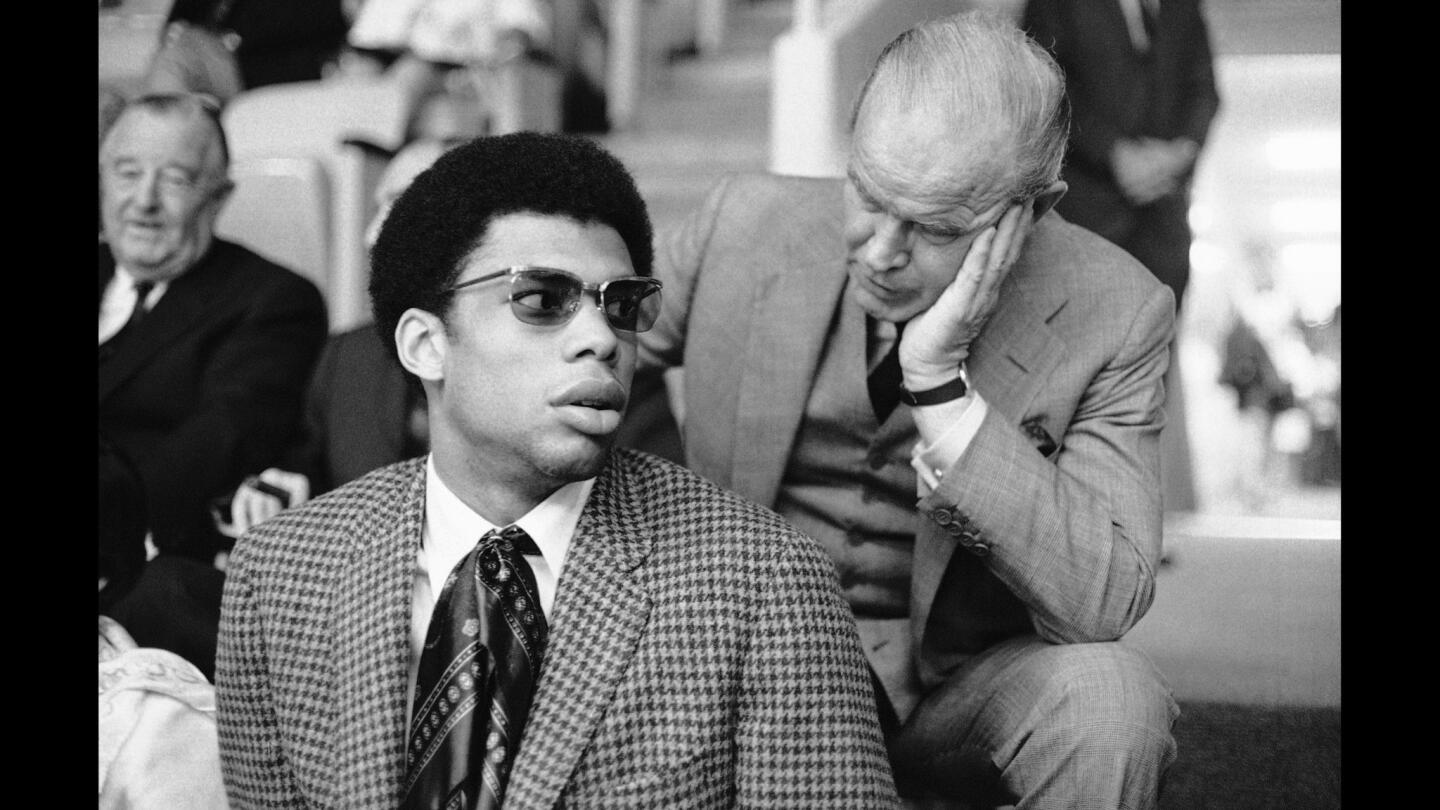 Three-time All American Lew Alcindor (Kareem Abdul-Jabbar) talks with owner Jack Kent Cooke of the NBA's Los Angeles Lakers just after telling the Associated Press he has agreed to sign a $1-million-plus contract with the Milwaukee Bucks. The two were talking in the Forum, March 28, 1969, in Los Angeles just before the start of a Laker-San Francisco Warriors playoff game.