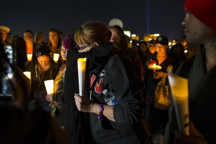 Allie Sibley of Upland, Calif., right, is comforted by a friend during a candle light vigil at Town Square to remember those killed and injured the day after a lone gunman open fired onto a county music festival on Oct. 2, 2017 in Las Vegas.