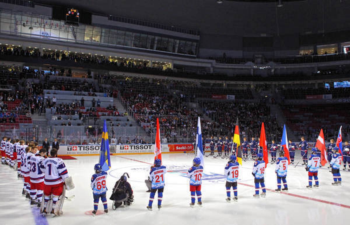 Russian President Vladimir Putin, second from the left in the background on the ice, attends the opening ceremony of the Ice Hockey U18 World Championships before a U.S.-Russian game in Sochi, Russia.