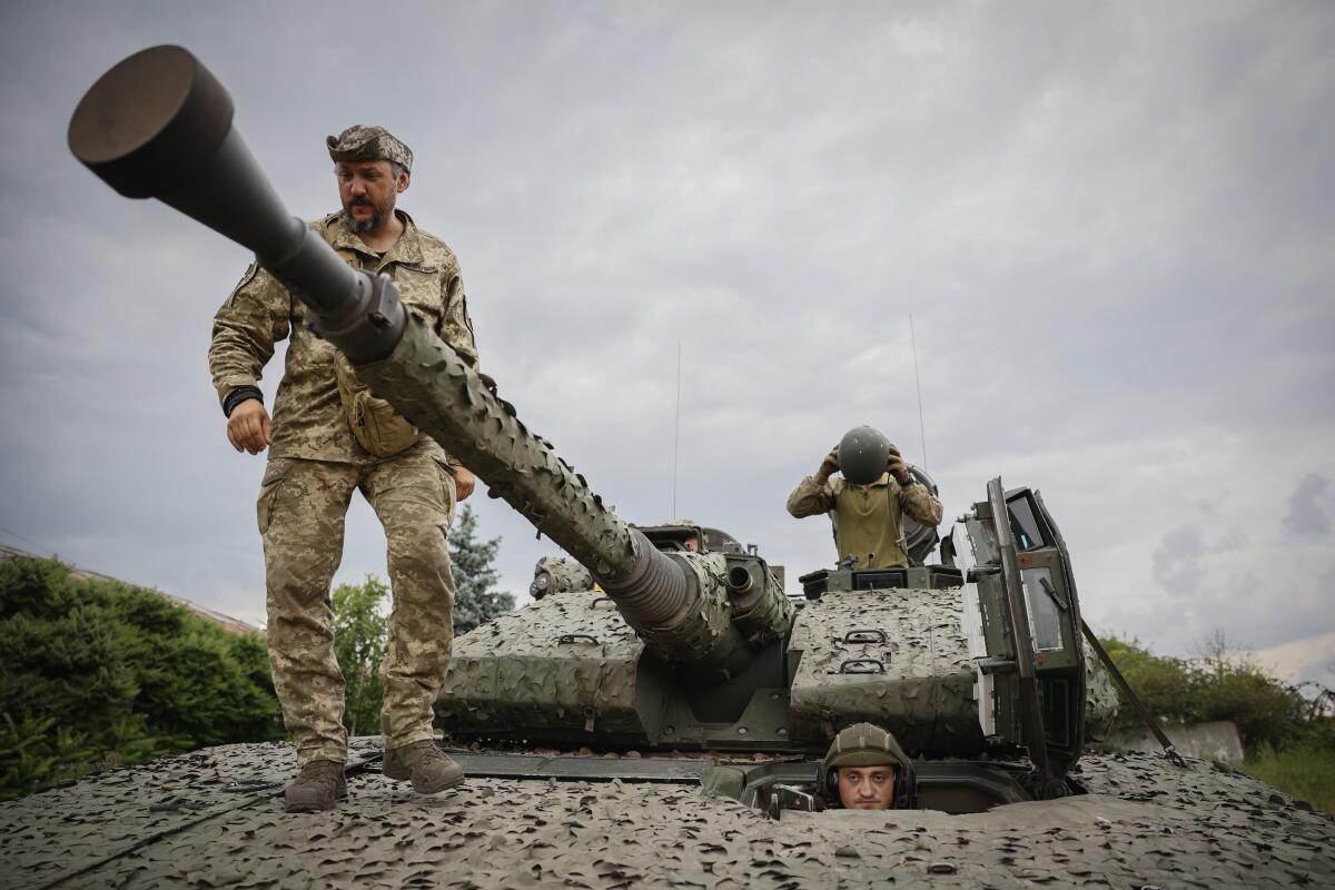 Ukrainian soldiers on a Swedish armored vehicle