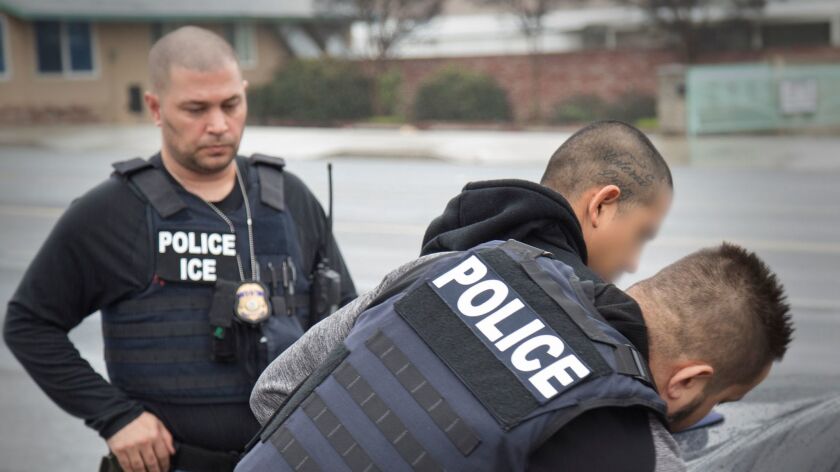 Immigration agents showing dual identification as police and ICE.