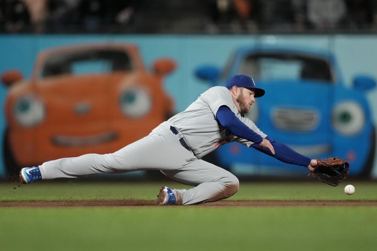 Dodgers third baseman Max Muncy can't corral a single hit by San Francisco's J.D. Davis during the sixth inning.