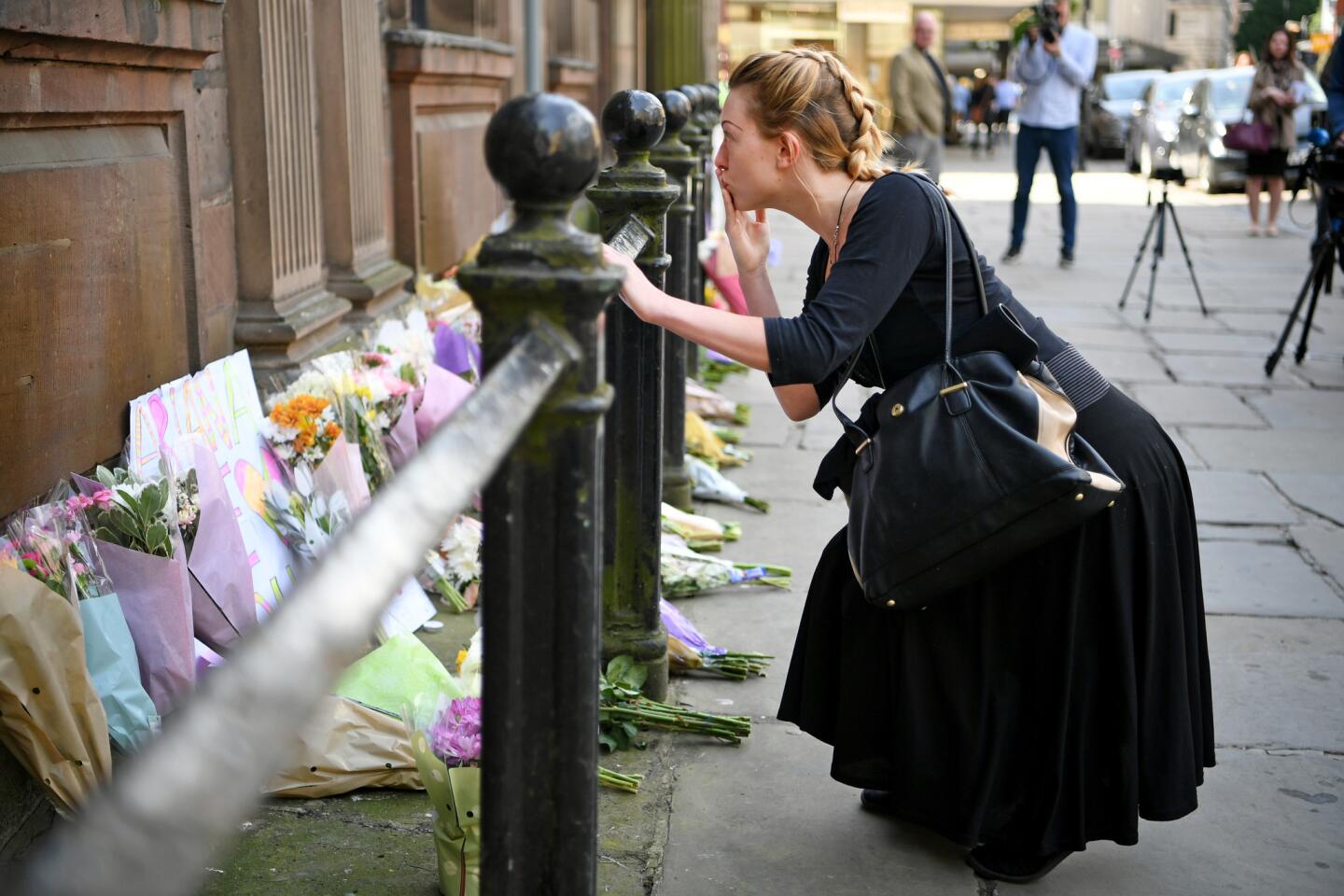 A woman pauses at a memorial in St. Ann Square on May 23, 2017, in Manchester, England, a day after 22 people were killed in a suicide bombing at a pop concert packed with children. It was the worst terror incident on British soil since the London bombings of 2005.