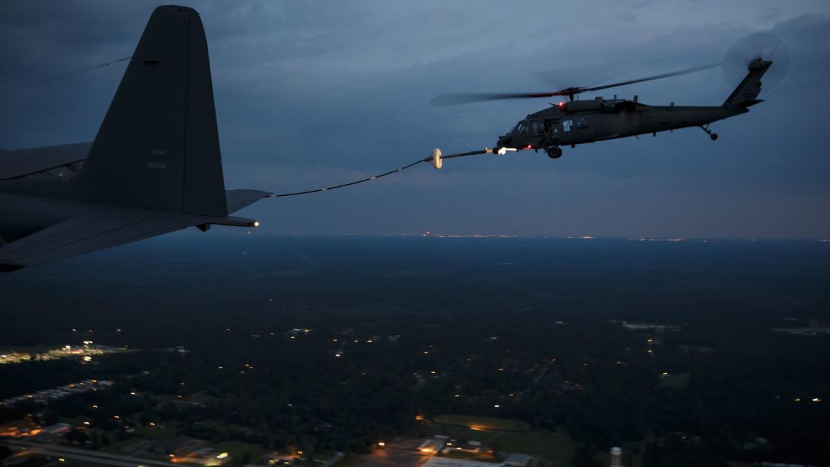 A military search and rescue helicopter refuels midflight before resuming nighttime missions over in Lumberton, Texas.