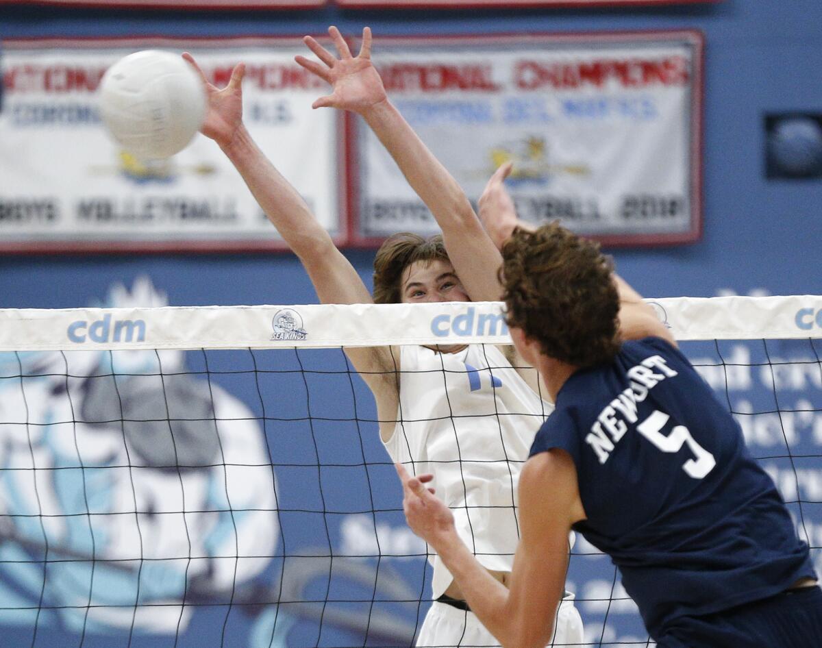 Corona del Mar's Sterling Foley (11) tries to block a kill by Newport Harbor's Riggs Guy (5) on Tuesday.