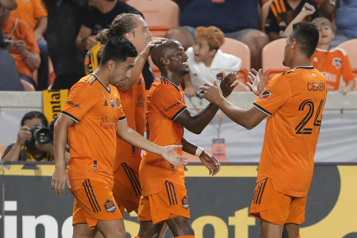 Houston Dynamo's Fafa Picault, center, is surrounded after his second goal of the game by team mates, from left, Memo Rodriguez, Griffin Dorsey and Darwin Ceren during the second half of an MLS soccer match against Austin FC Saturday, Sept. 11, 2021, in Houston. (AP Photo/Michael Wyke)