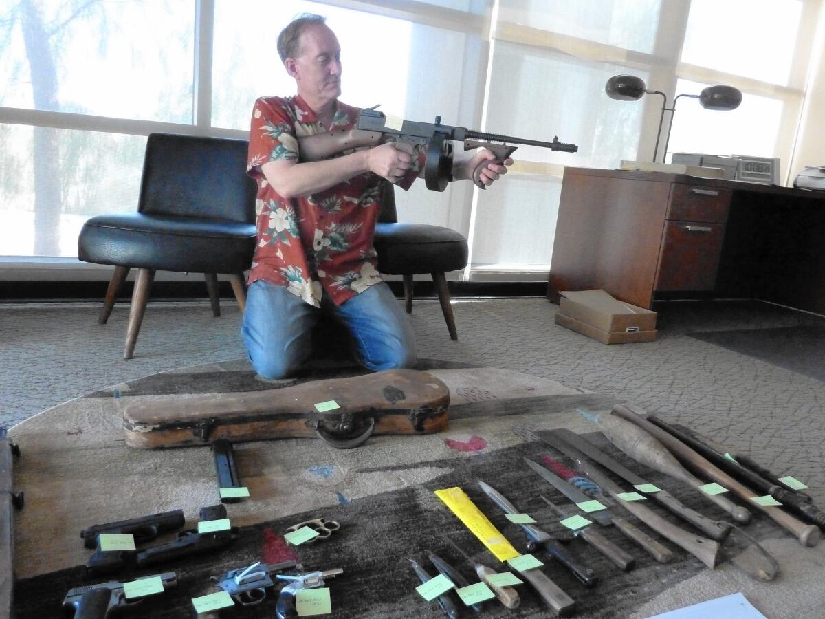 Dennis McBride, director of the Nevada State Museum in Las Vegas, displays mobsters' weapons donated by collector Richard Greeno.