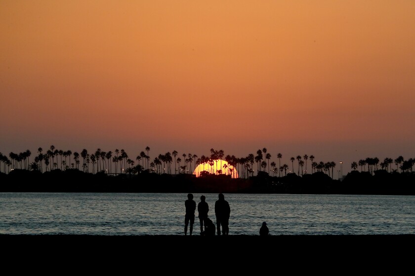 LONGG BEACH, CA. - NOV. 24, 2020. Beachgoers watch the sunset in Belmont Shore on Tuesday, Nov. 24, 2020. Mild, sunny weather is forecast for Southern California over the Thanksgiving weekend. (Luis Sinco/Los Angeles Times)