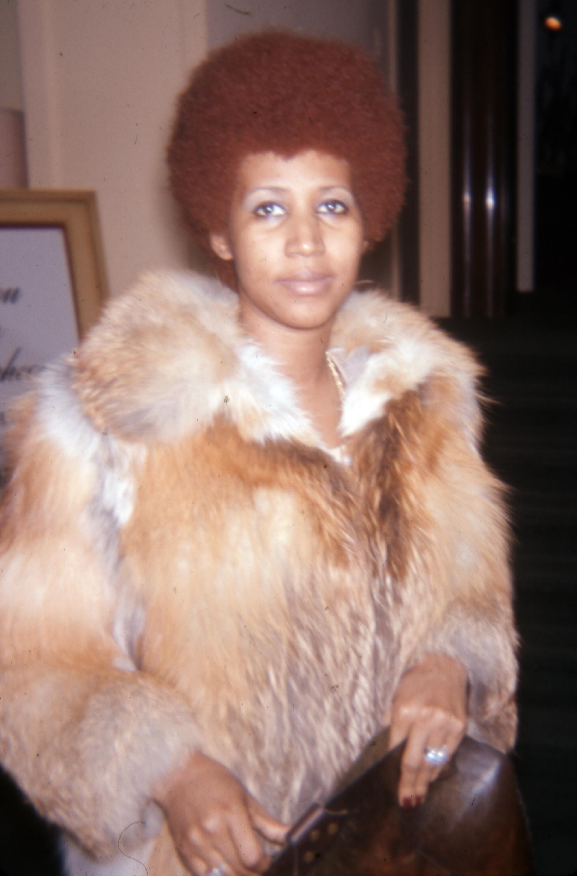 A woman in a light-brown fur coat.