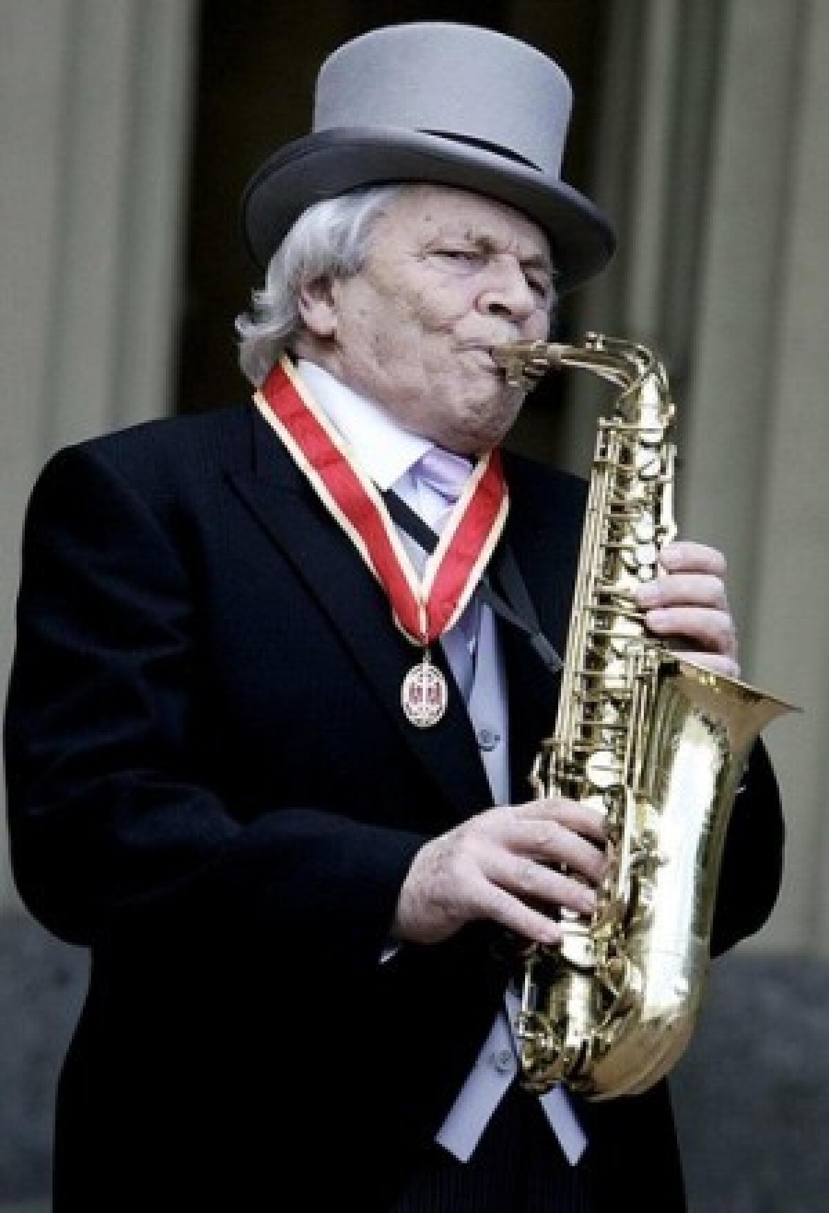 John Dankworth plays his saxophone at Buckingham Palace in 2006 after receiving a knighthood from Queen Elizabeth II.