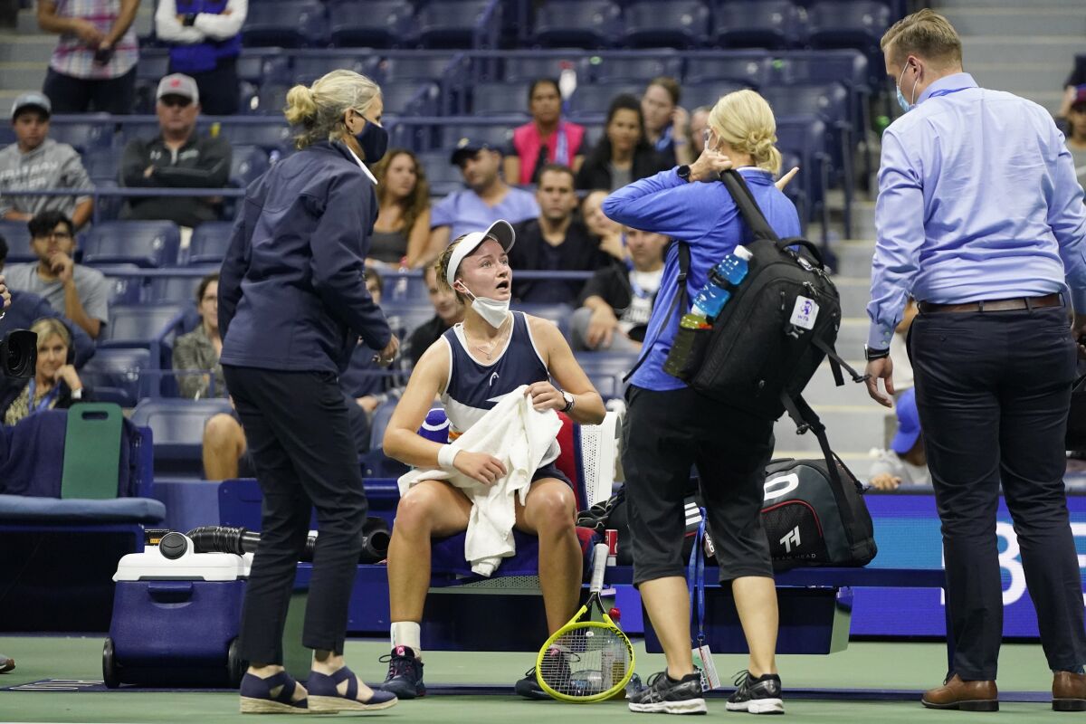 Barbora Krejcikova, of the Czech Republic, is checked by medical personnel during her match against Garbine Muguruza, of Spain, in the fourth round of the US Open tennis championships, Sunday, Sept. 5 2021, in New York. Krejcikova won the match. (AP Photo/Frank Franklin II)