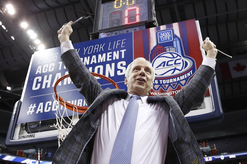 North Carolina Coach Roy Williams holds part of the net after his Tar Heels defeated Virginia in the ACC championship game on March 12.